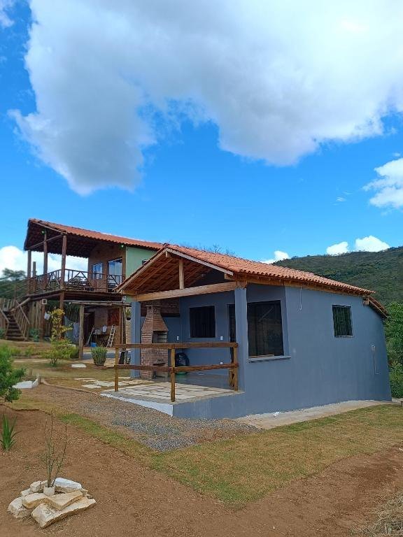 Os chalés do Refúgio São Tomé com a serra e o céu azul ao fundo